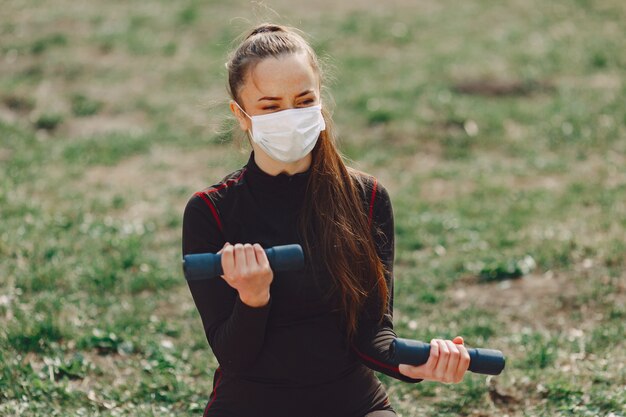 Ragazza sveglia che fa yoga in un parco di estate