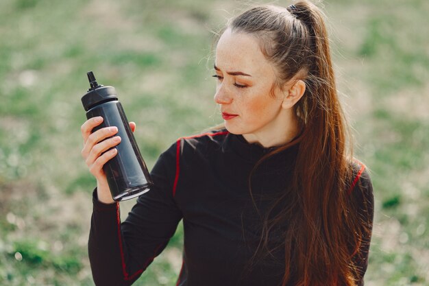 Ragazza sveglia che fa yoga in un parco di estate