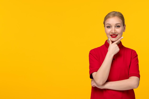 Ragazza sveglia di giorno della camicia rossa che sorride felicemente in una camicia rossa su una priorità bassa gialla