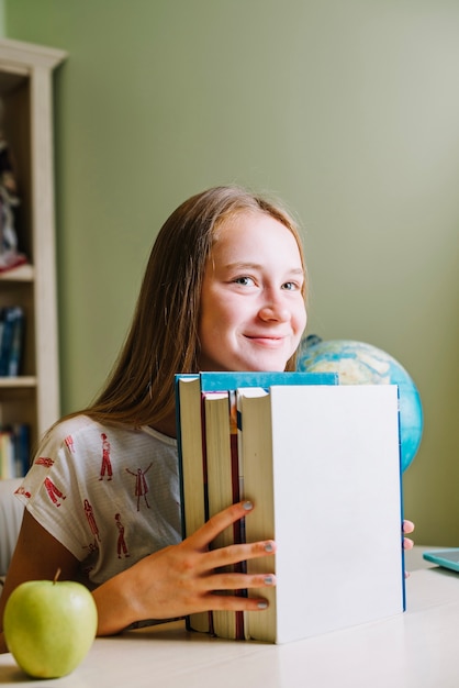 Ragazza teen felice con i libri impilati