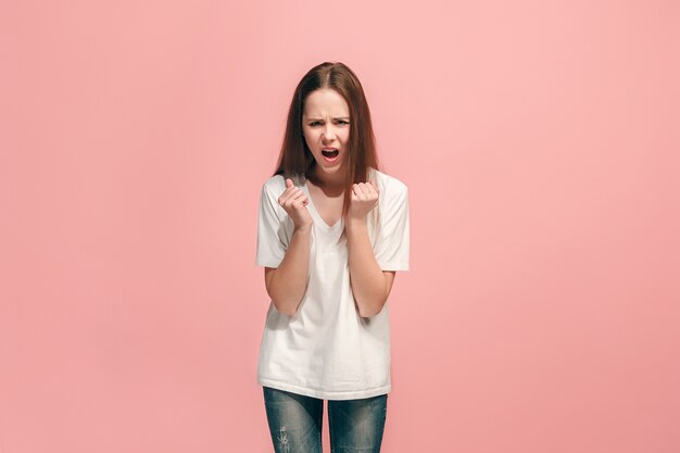 Ragazza teenager arrabbiata che sta sullo studio blu alla moda.