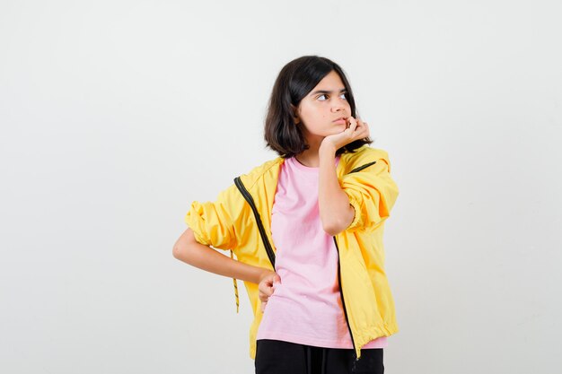 Ragazza teenager che controlla i suoi denti, distoglie lo sguardo in maglietta, giacca e sembra annoiata. vista frontale.