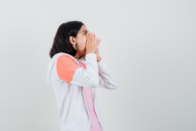 Ragazza teenager che grida in giacca, camicia rosa