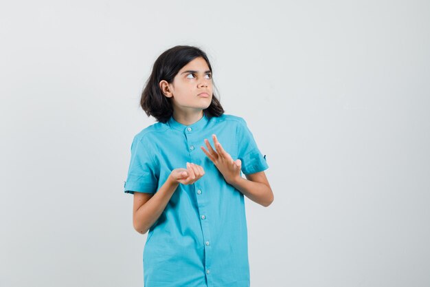 Ragazza teenager che si mette nei guai in camicia blu e che sembra perplessa
