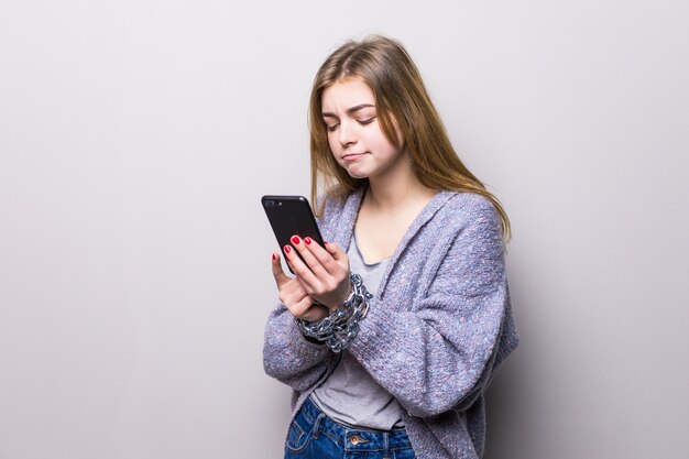 Ragazza teenager con le mani bloccate a catena utilizzando uno smartphone isolato
