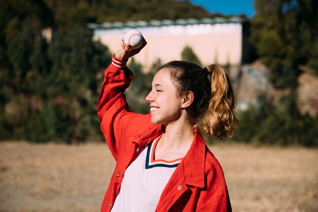 Ragazza teenager felice con la palla per baseball