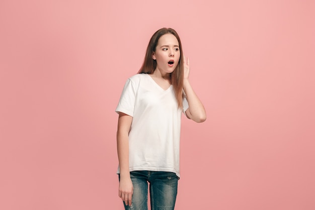 ragazza teenager felice in piedi e in ascolto su sfondo rosa alla moda per studio.