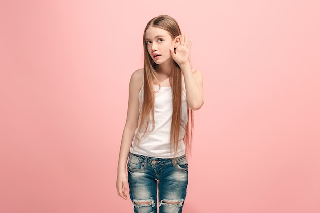 ragazza teenager felice in piedi e in ascolto sul rosa alla moda. Bellissimo ritratto femminile a mezzo busto