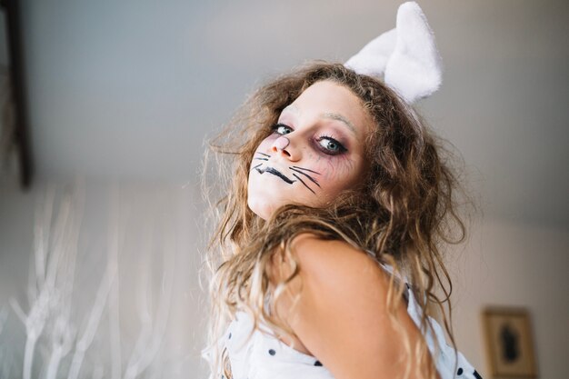 Ragazza teenager sveglia in vernice viso di Halloween