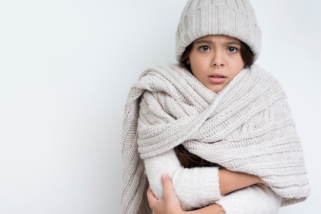 Ragazza vestita calorosamente con le mani giunte al petto