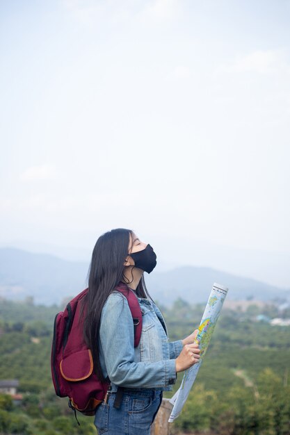 Ragazza viaggiatrice che cerca la giusta direzione sulla mappa