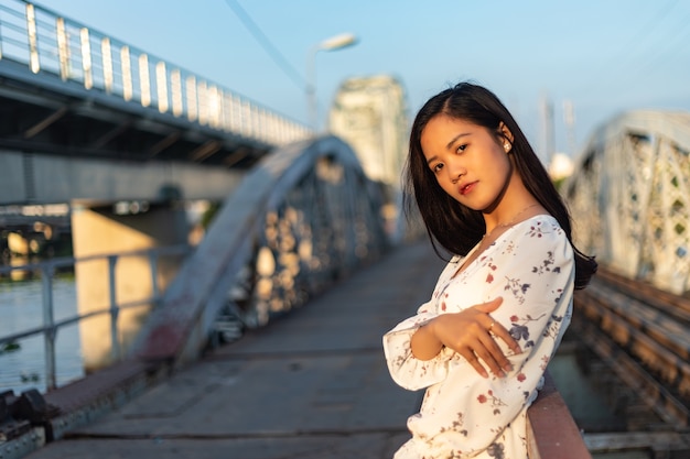 Ragazza vietnamita dai capelli neri su un ponte