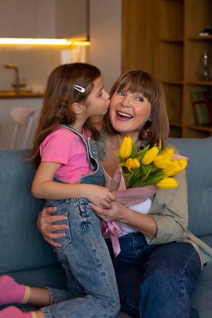 Ragazza vista frontale con nonna e fiori