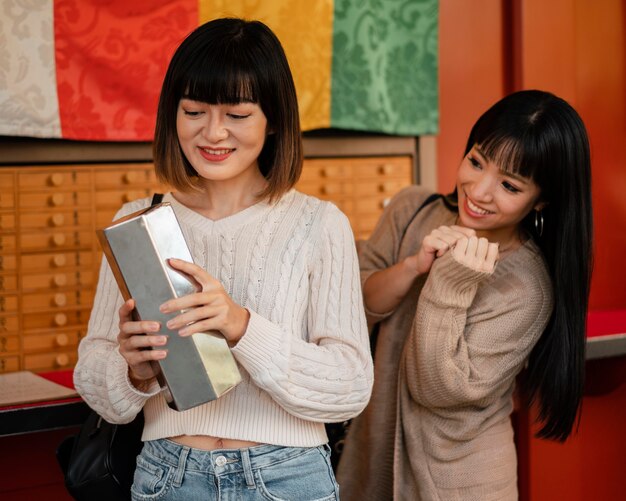 Ragazze abbastanza asiatiche che controllano insieme un prodotto