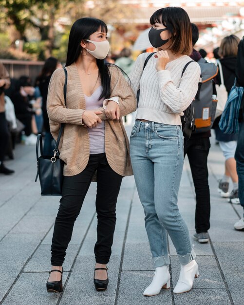 Ragazze abbastanza asiatiche che indossano maschere per il viso