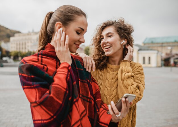 Ragazze abbastanza giovani che controllano insieme un telefono