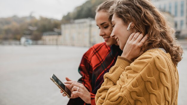 Ragazze abbastanza giovani che controllano insieme un telefono