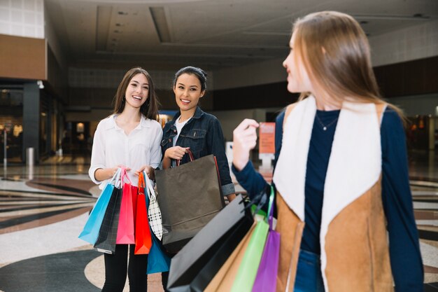 Ragazze alla moda che presentano nel centro commerciale