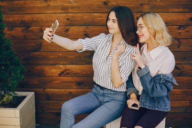 ragazze alla moda che si siedono in una città