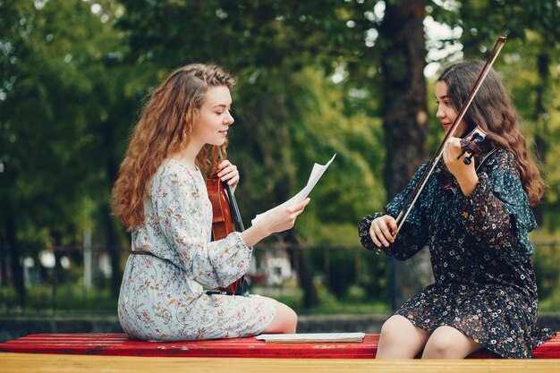 Ragazze belle e romantiche in un parco con un violino