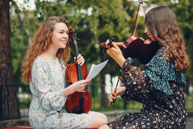 Ragazze belle e romantiche in un parco con un violino