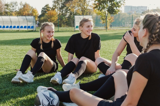 Ragazze bionde sorridenti che si siedono sull'erba