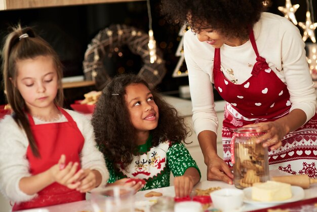 Ragazze che aiutano la mamma a preparare i biscotti per Natale