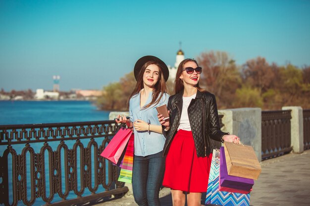 ragazze che camminano con lo shopping per le strade della città