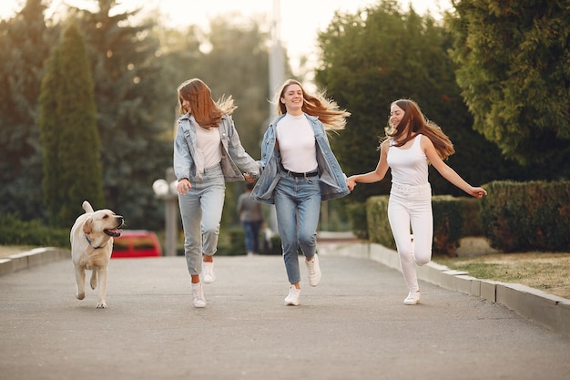 Ragazze che camminano in una città di primavera con cane carino