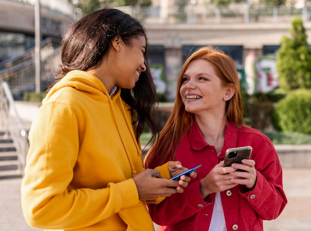 Ragazze che controllano i loro telefoni all'aperto