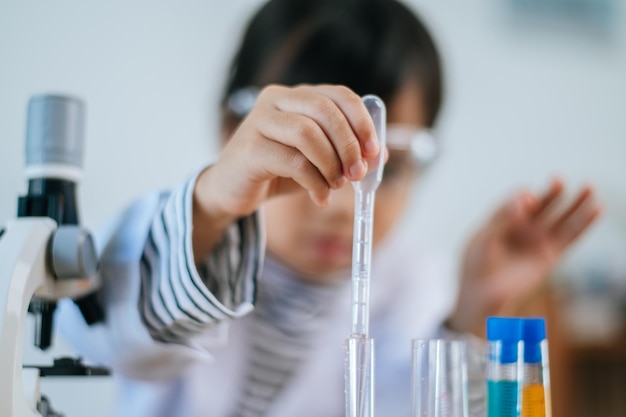 Ragazze che fanno esperimenti scientifici in laboratorio. Messa a fuoco selettiva.