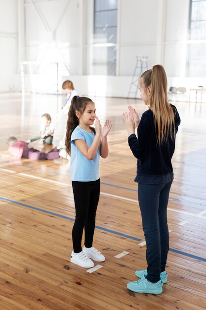 Ragazze che giocano in palestra a tutto campo
