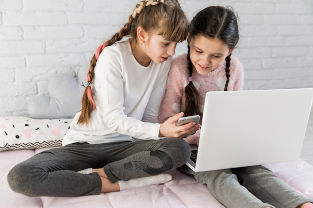 Ragazze che per mezzo del computer portatile