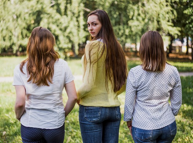 Ragazze dell'adolescente che posano per la macchina fotografica con la parte posteriore