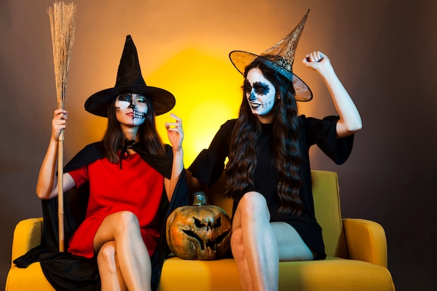Ragazze di Halloween sul divano con zucca