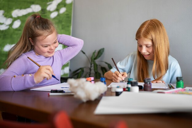 Ragazze di smiley del colpo medio che dipingono insieme