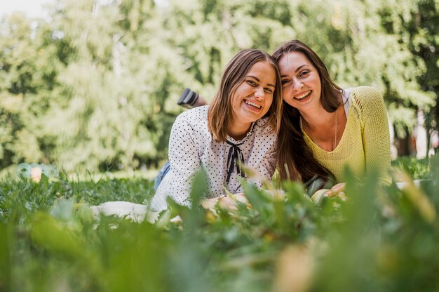 Ragazze di smiley dell'adolescente che si siedono nell'erba