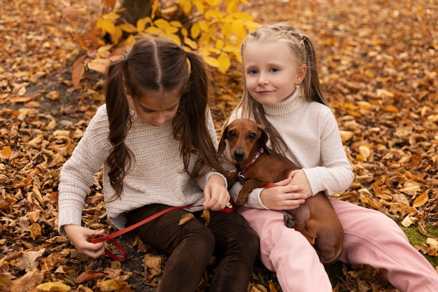 Ragazze di tiro medio con cane in natura