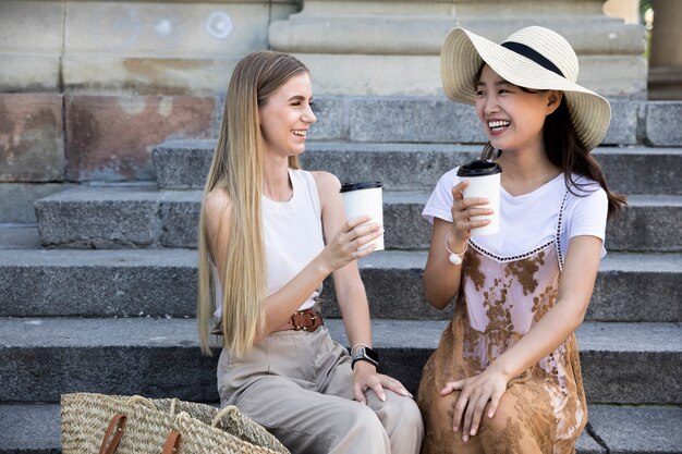 Ragazze di vista frontale che hanno una tazza di caffè