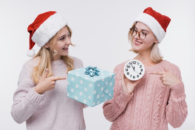 Ragazze di vista frontale che tengono un contenitore di regalo