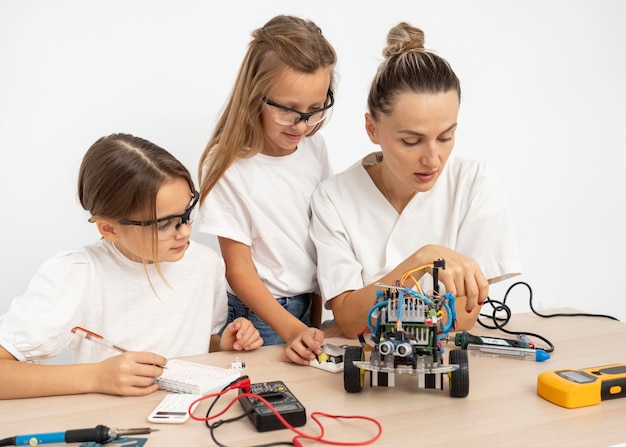 Ragazze e insegnante femminile che fanno insieme esperimenti scientifici