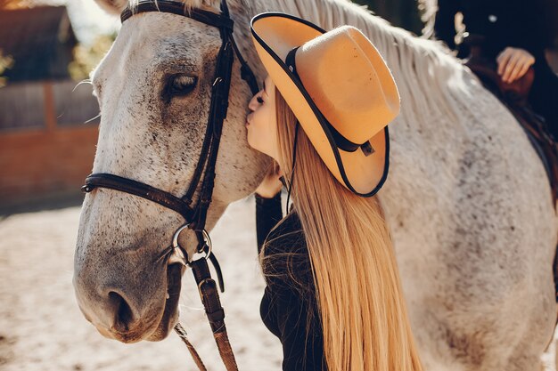 Ragazze eleganti con un cavallo in un ranch