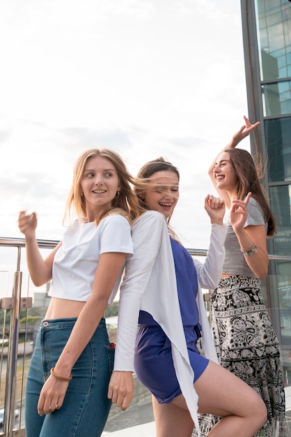 Ragazze felici che ballano schiena contro schiena