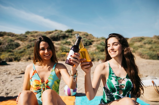 Ragazze in spiaggia brindando con la birra