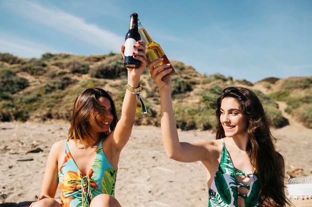 Ragazze in spiaggia brindando con la birra