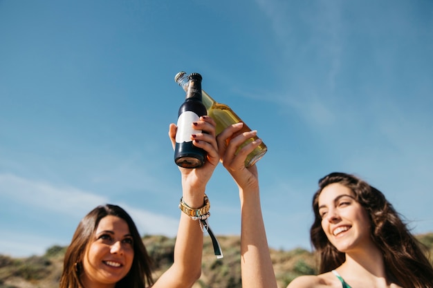 Ragazze in spiaggia brindando con la birra