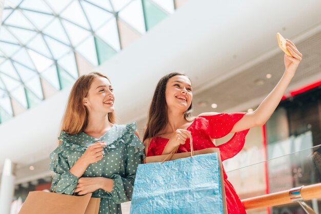 Ragazze medie del colpo al centro commerciale che prende un selfie