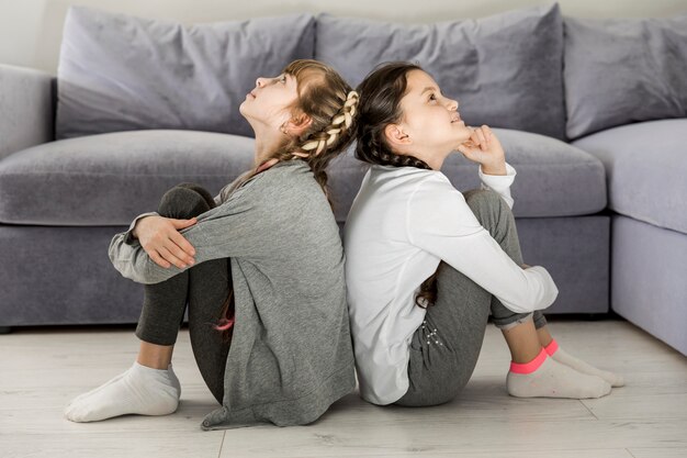 Ragazze sedute schiena contro schiena