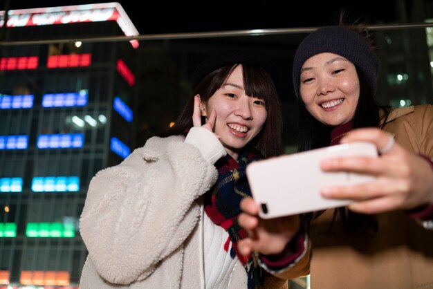 Ragazze sorridenti del colpo medio che prendono selfie