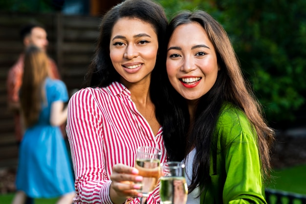 Ragazze sorridenti del primo piano con i vetri del champagne